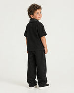 Little boy wearing the Romimi Adam Braided Collar Polo - Black, back view