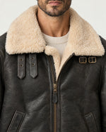 Detail of the Romimi aviator jacket in black with a cream collar: the cream collar, front zip and buckle straps