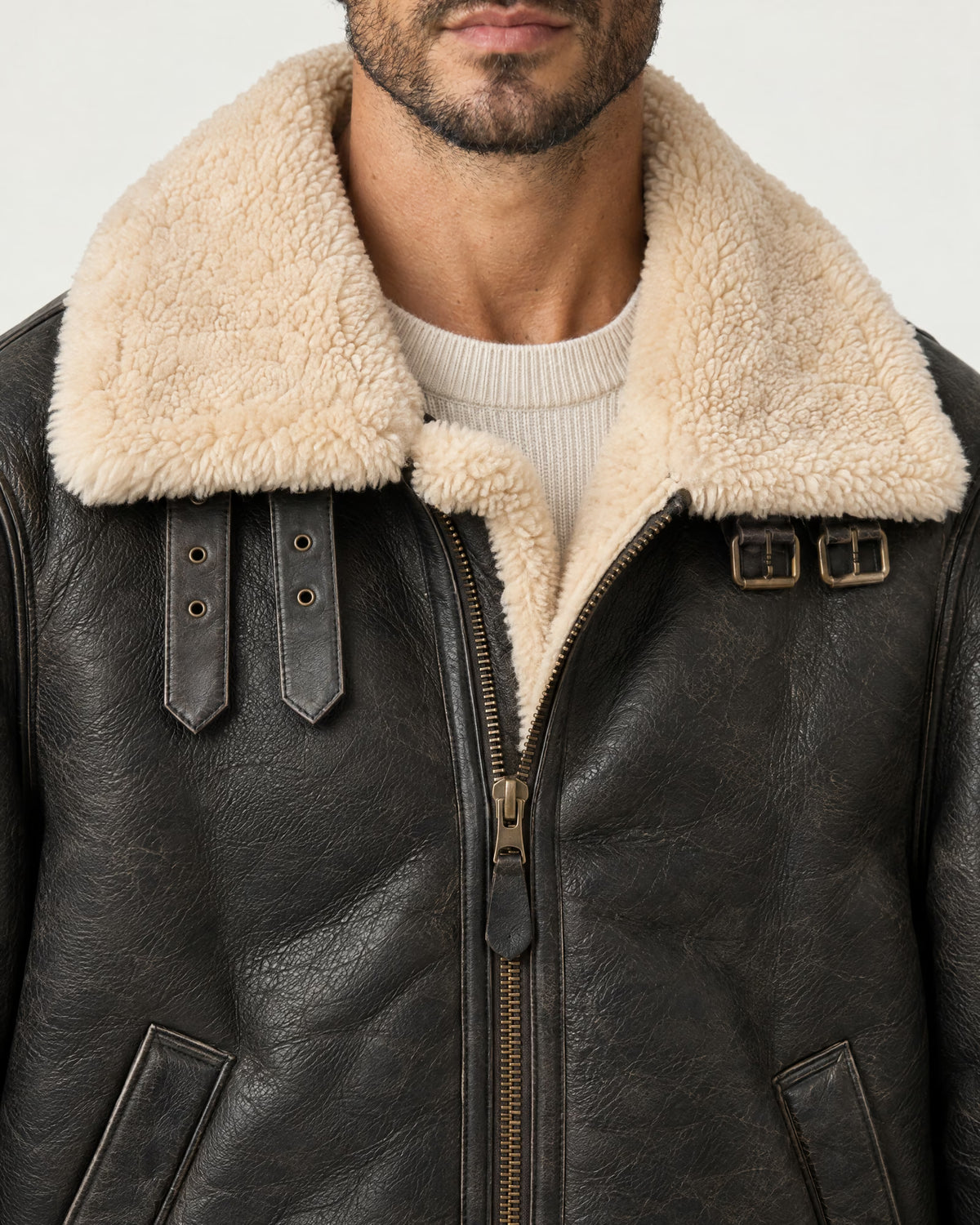 Detail of the Romimi aviator jacket in black with a cream collar: the cream collar, front zip and buckle straps