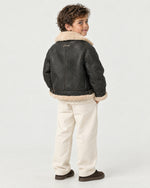 Boy wearing the Romimi kids aviator jacket in black with a cream collar, back view