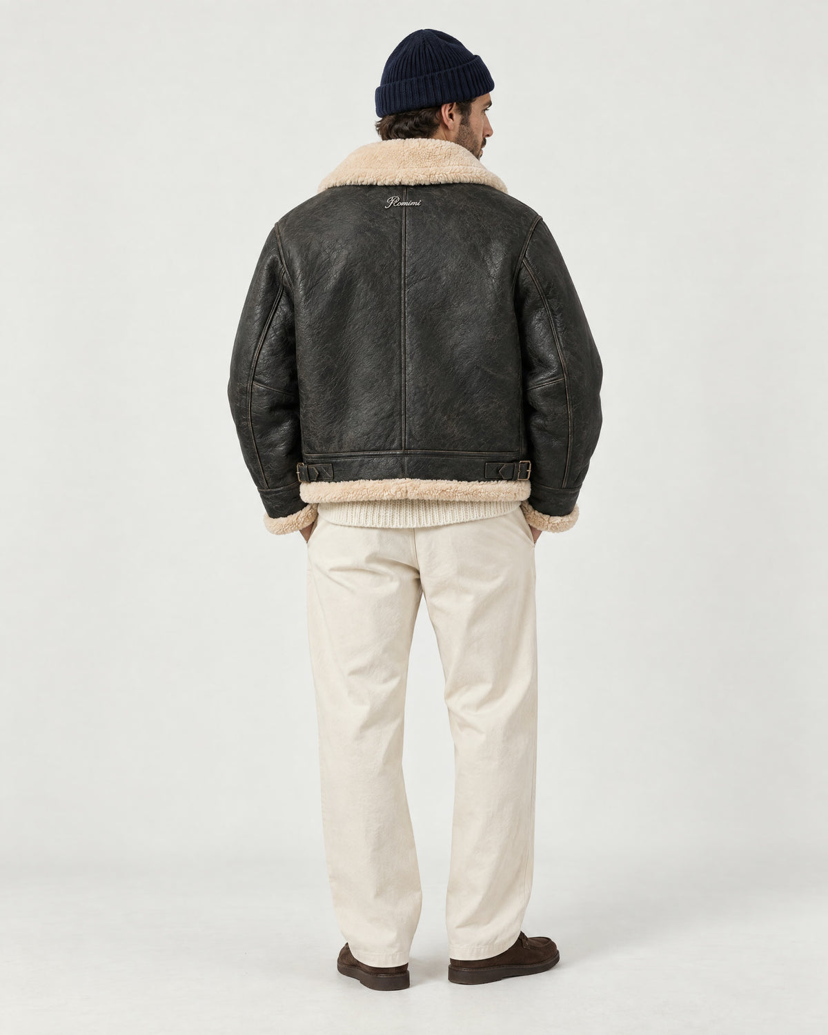 Man wearing the Romimi aviator jacket in black with a cream collar, back view