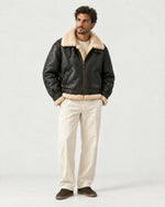 Man wearing the Romimi aviator jacket in black with a cream collar, full length