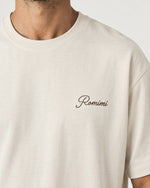 Detail of the Romimi graphic tee in cream with the Andorra ski print: the small Romimi script on the chest