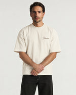 Man wearing the Romimi Graphic Tee - Beige, front view