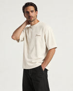 Man wearing the Romimi Graphic Tee - Beige, three-quarter view