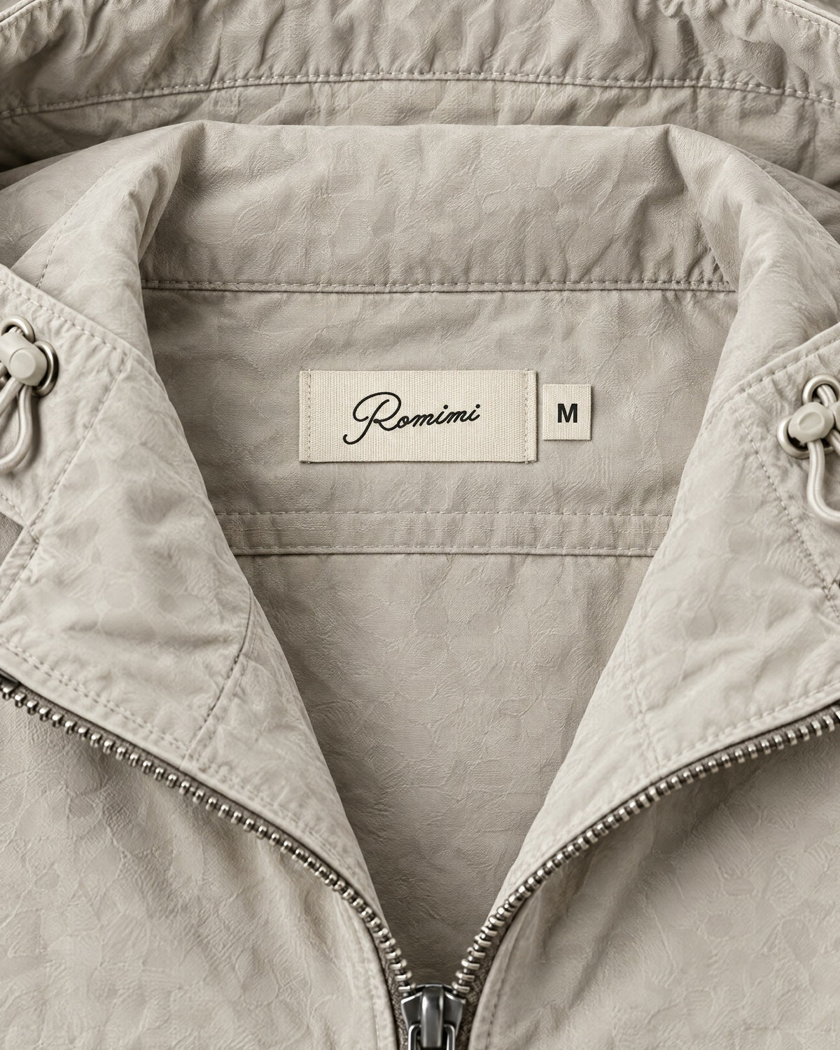 Romimi Hooded Tech Jacket in Beige, label close-up
