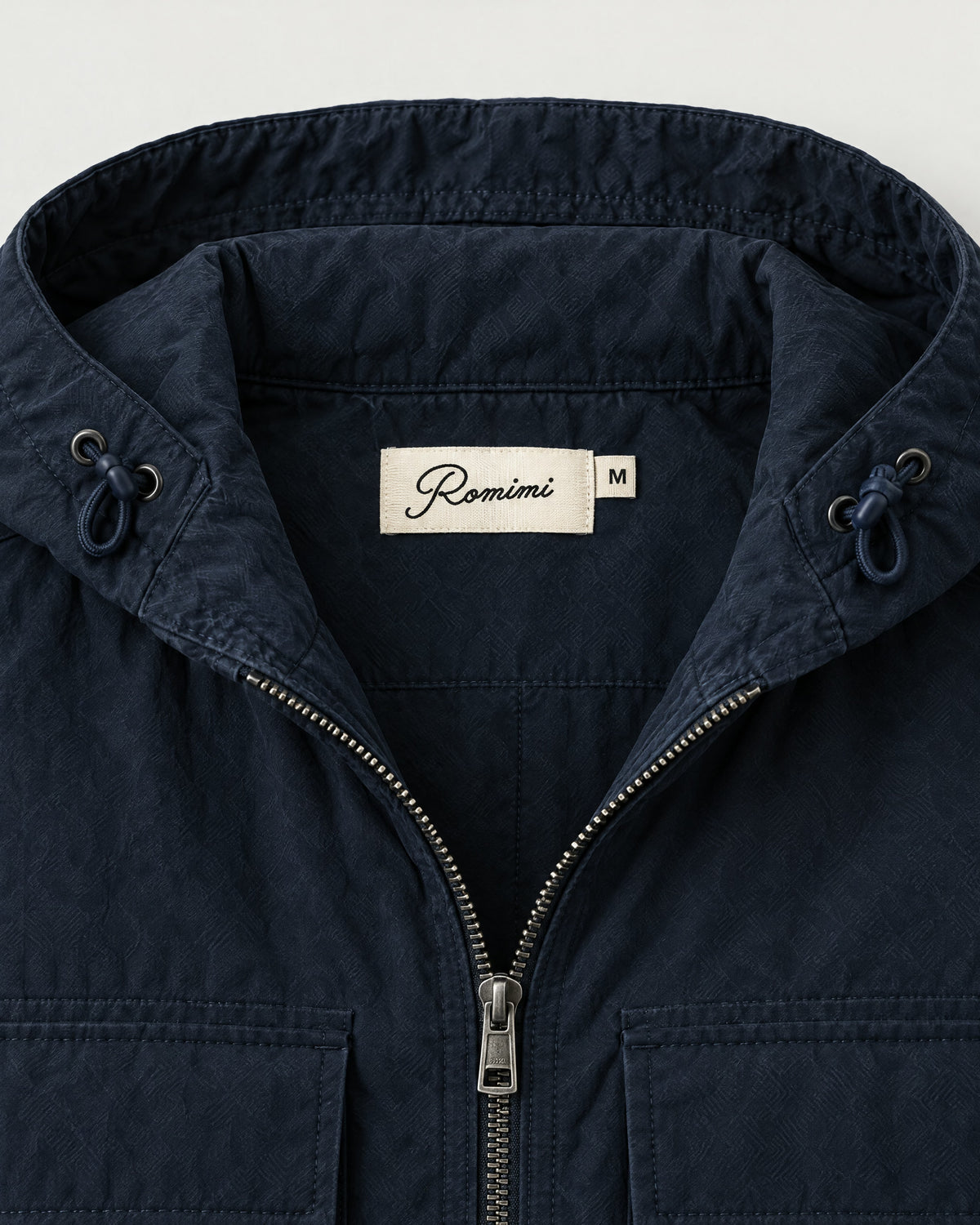 Romimi Hooded Tech Jacket in Navy, label close-up