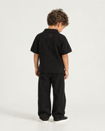 Little boy wearing the Romimi Laurent Classic Ribbed Polo, back view
