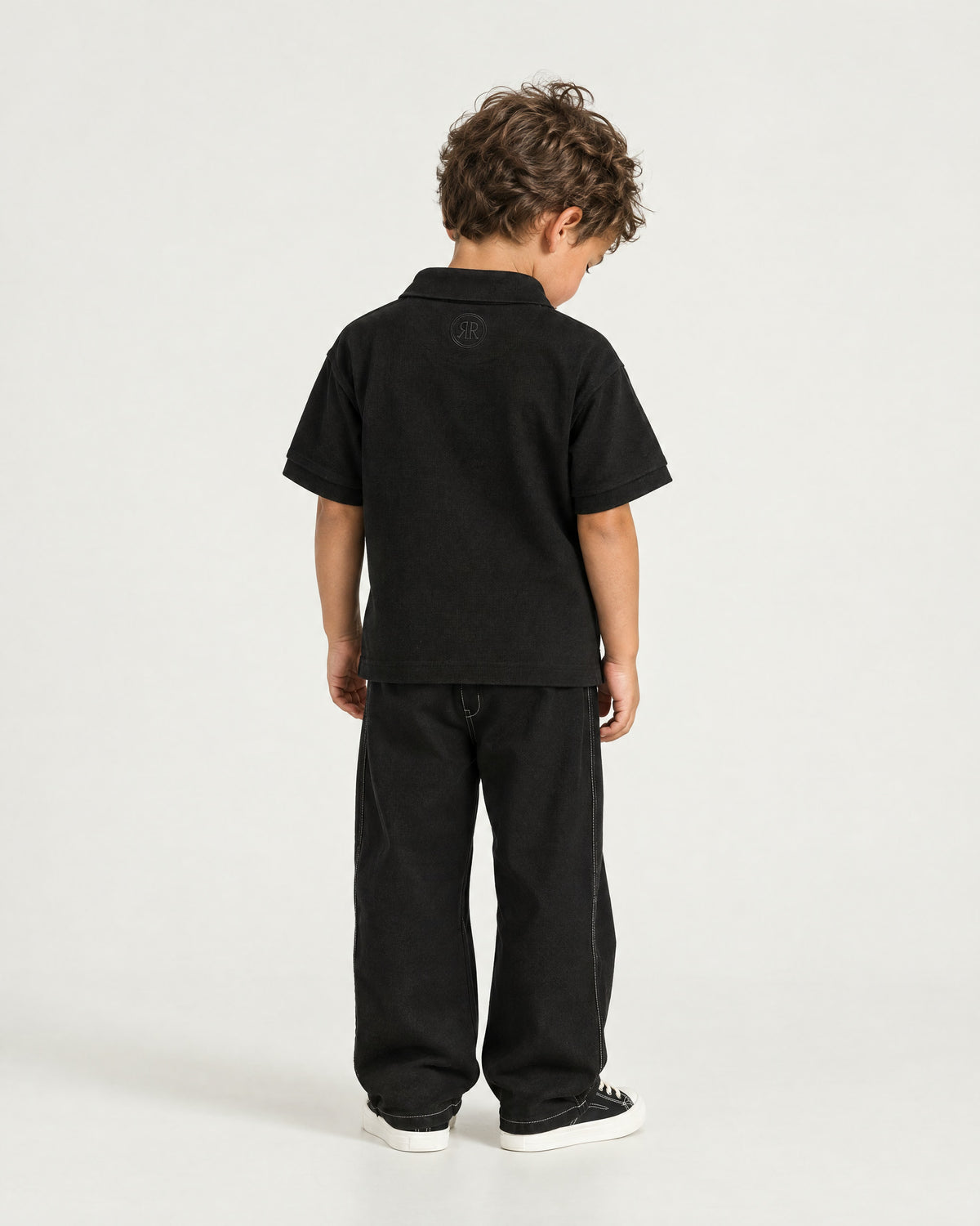 Little boy wearing the Romimi Laurent Classic Ribbed Polo, back view