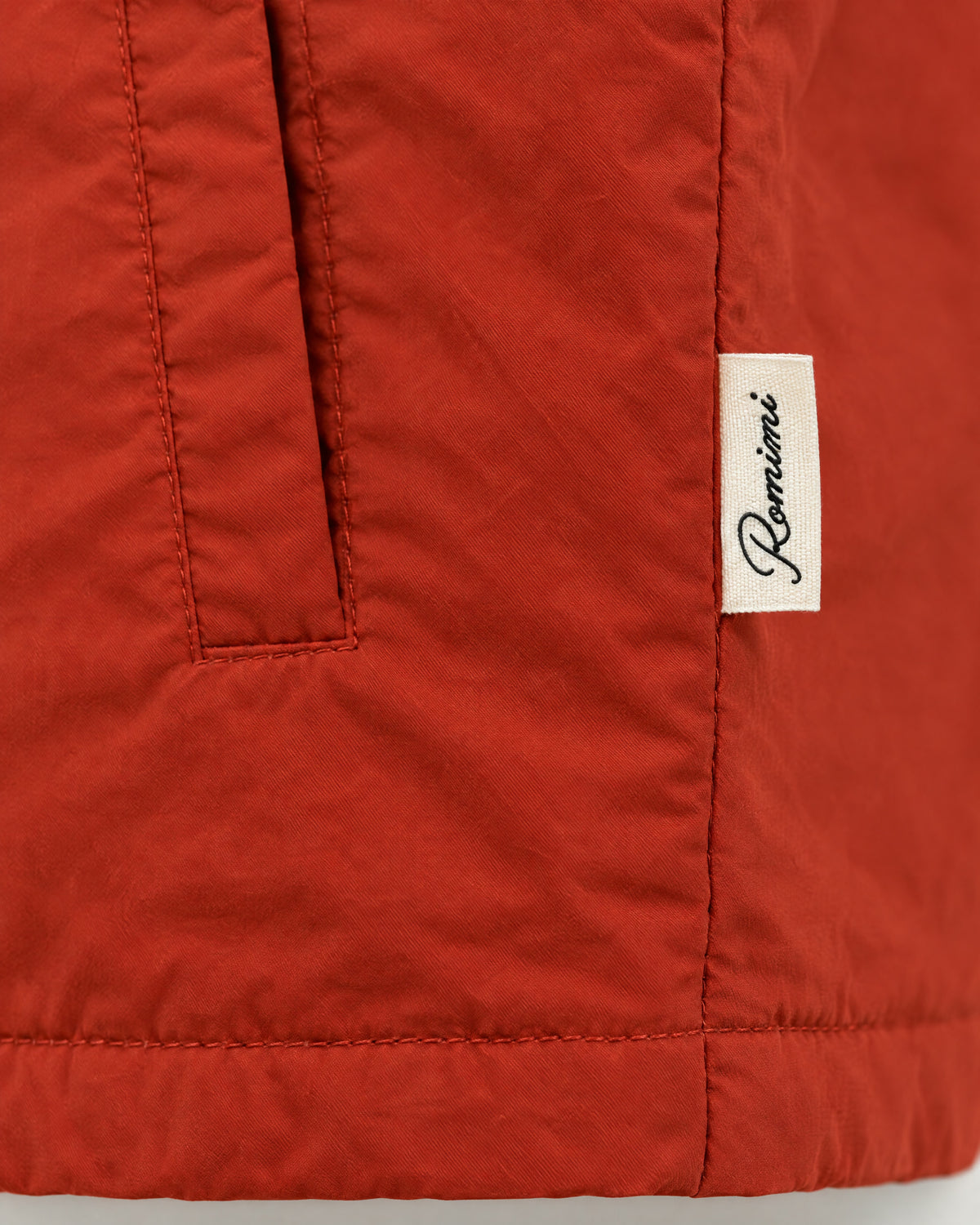 Romimi Reversible Windbreaker Gilet in Brick, label close-up