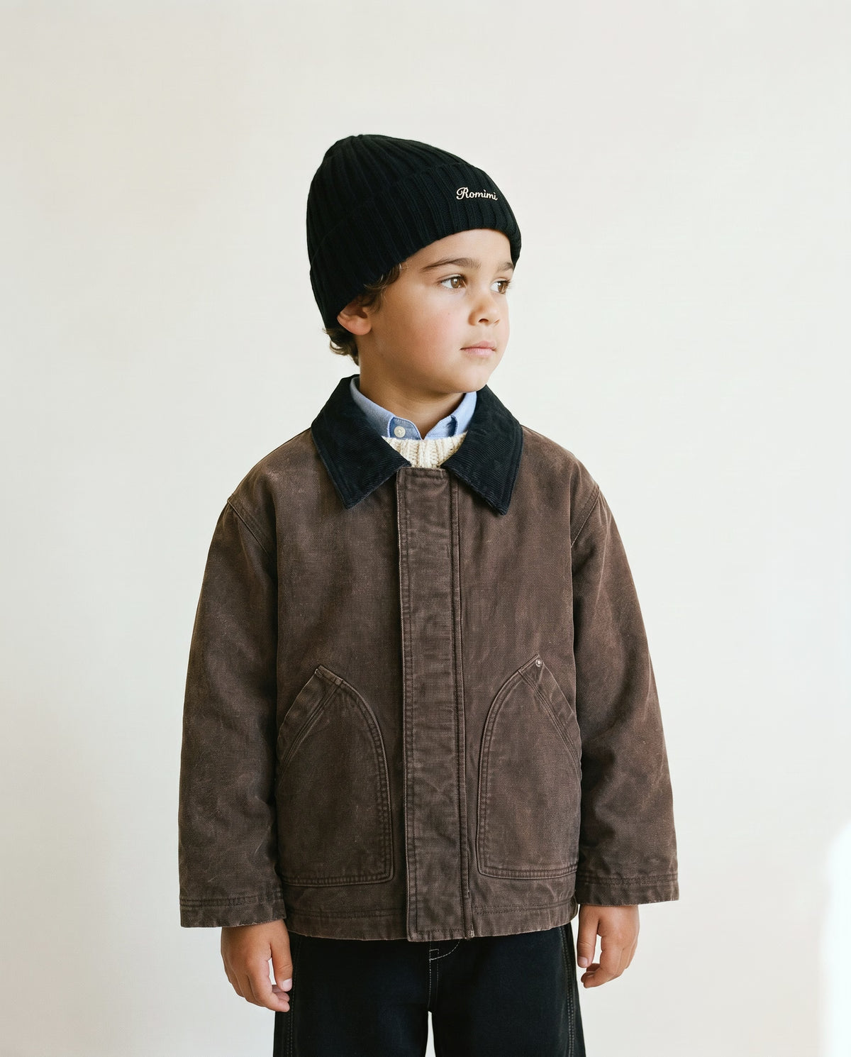 Little boy wearing the kids' rib-knit beanie in black, side view