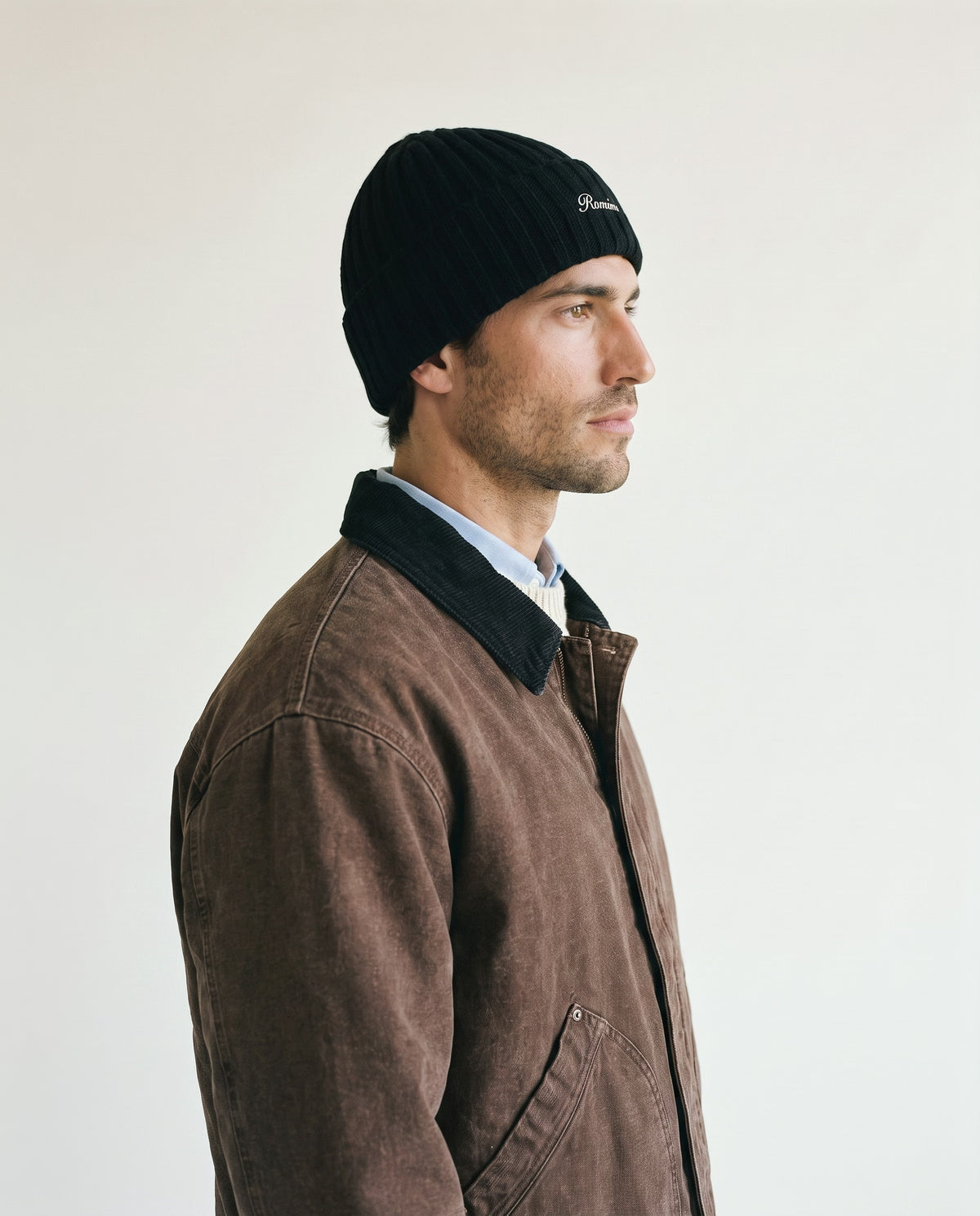Man wearing the rib-knit beanie in black, side view