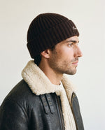 Man wearing the rib-knit beanie in chocolate, side view