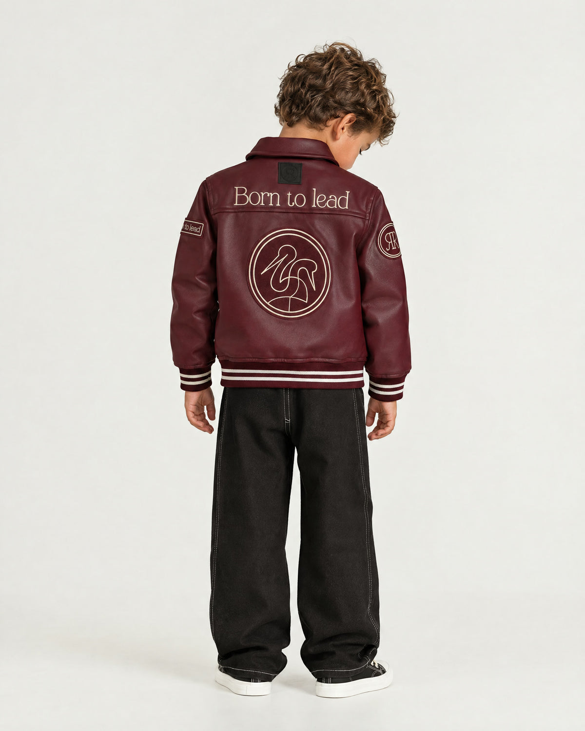 Little boy wearing the Romimi Signature Classic Bombers, back view