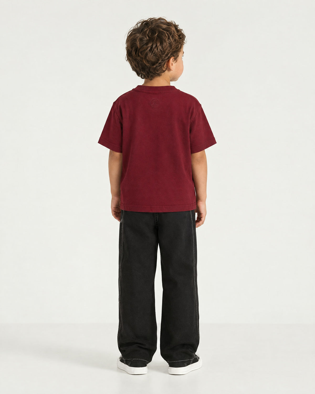 Little boy wearing the Romimi Signature Crest Tee, back view