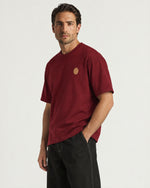 Man wearing the Romimi Signature Crest Tee, three-quarter view