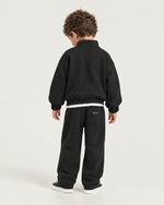 Little boy wearing the Romimi Tracksuit Pant - Black, back view