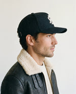 Man wearing the wool baseball cap in black, side view
