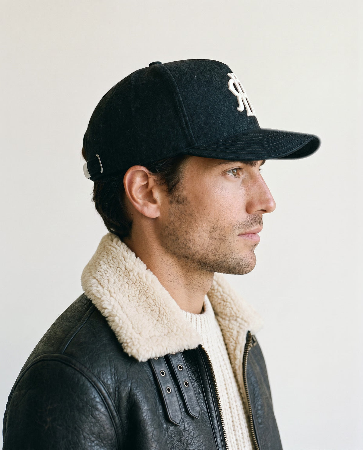 Man wearing the wool baseball cap in black, side view