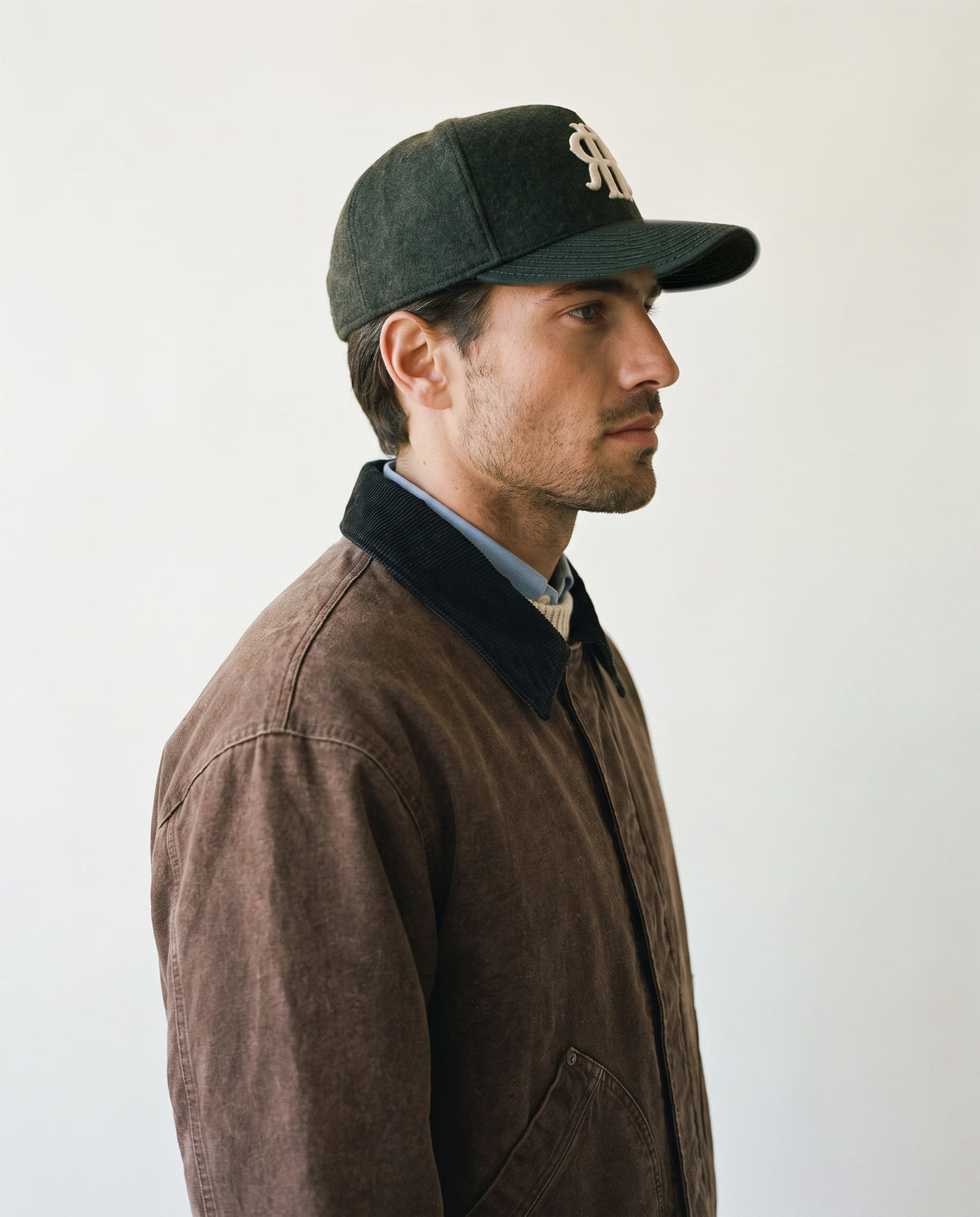 Man wearing the wool baseball cap in dark olive, side view